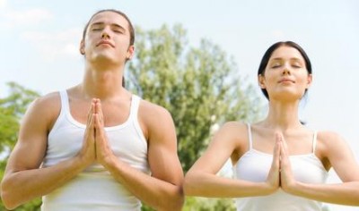 Young couple doing yoga moves or meditating together